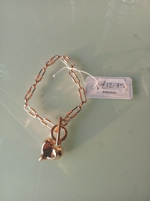 Gold tone paperclip chain bracelet with squashed heart. T Bar