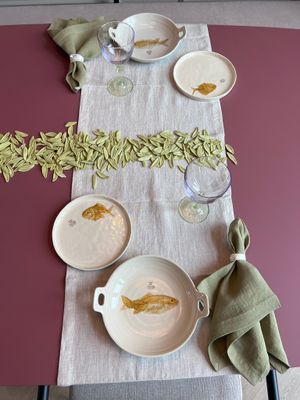 Tafellinnen met linnen tafelloper, servetten en gedekte tafel met servies van Smaak Zandvoort