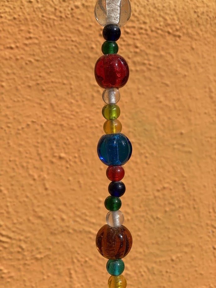 A Mix Of Colors Glass Beads And Bell