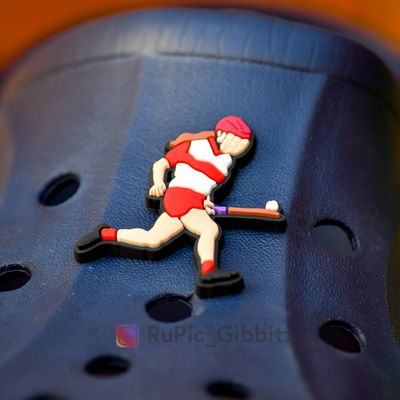Camogie player soloing in red &amp; white kit