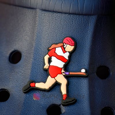 Camogie player soloing in red & white kit