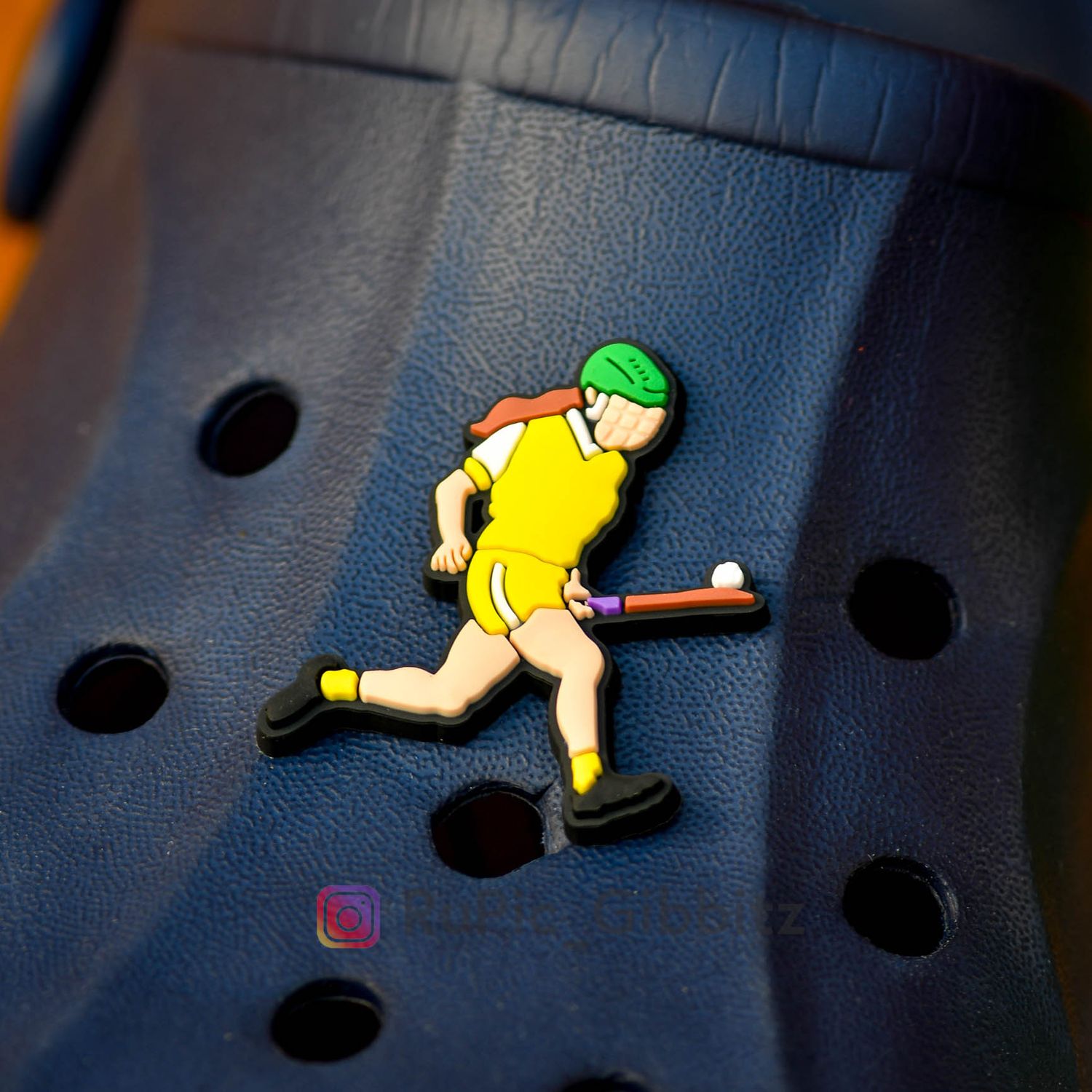 Camogie player soloing in an all yellow kit