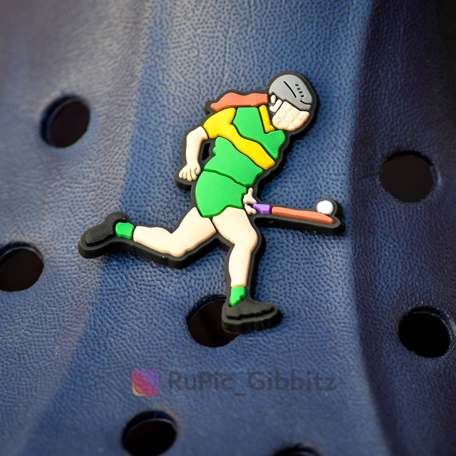 Camogie player soloing in green &amp; gold kit