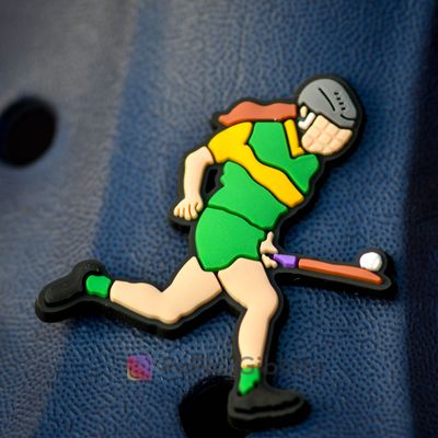 Camogie player soloing in green & gold kit