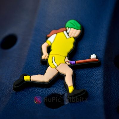 Camogie player soloing in an all yellow kit