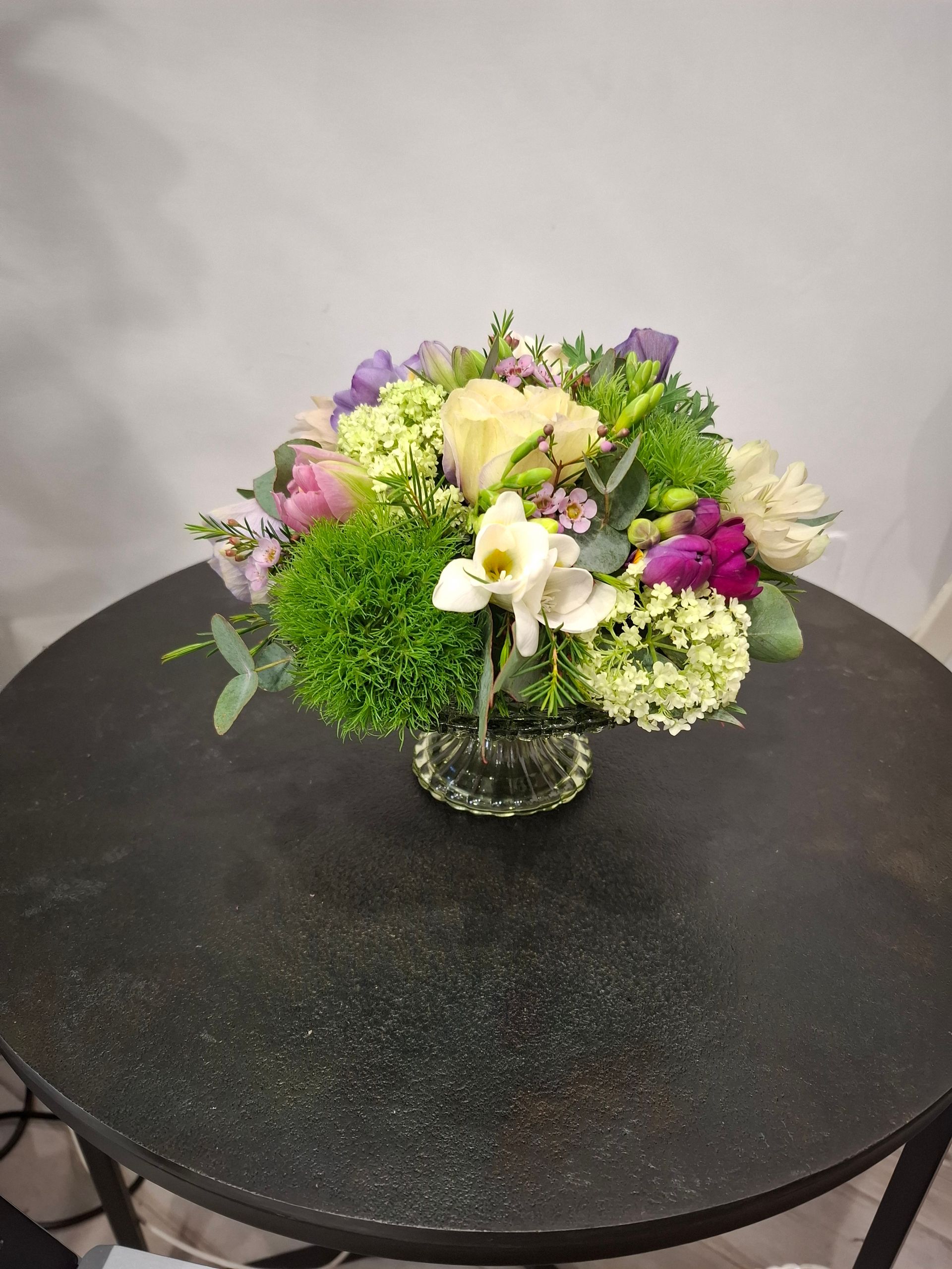 Composizione su alzata in vetro. Toni del rosa, bianco, rosso,