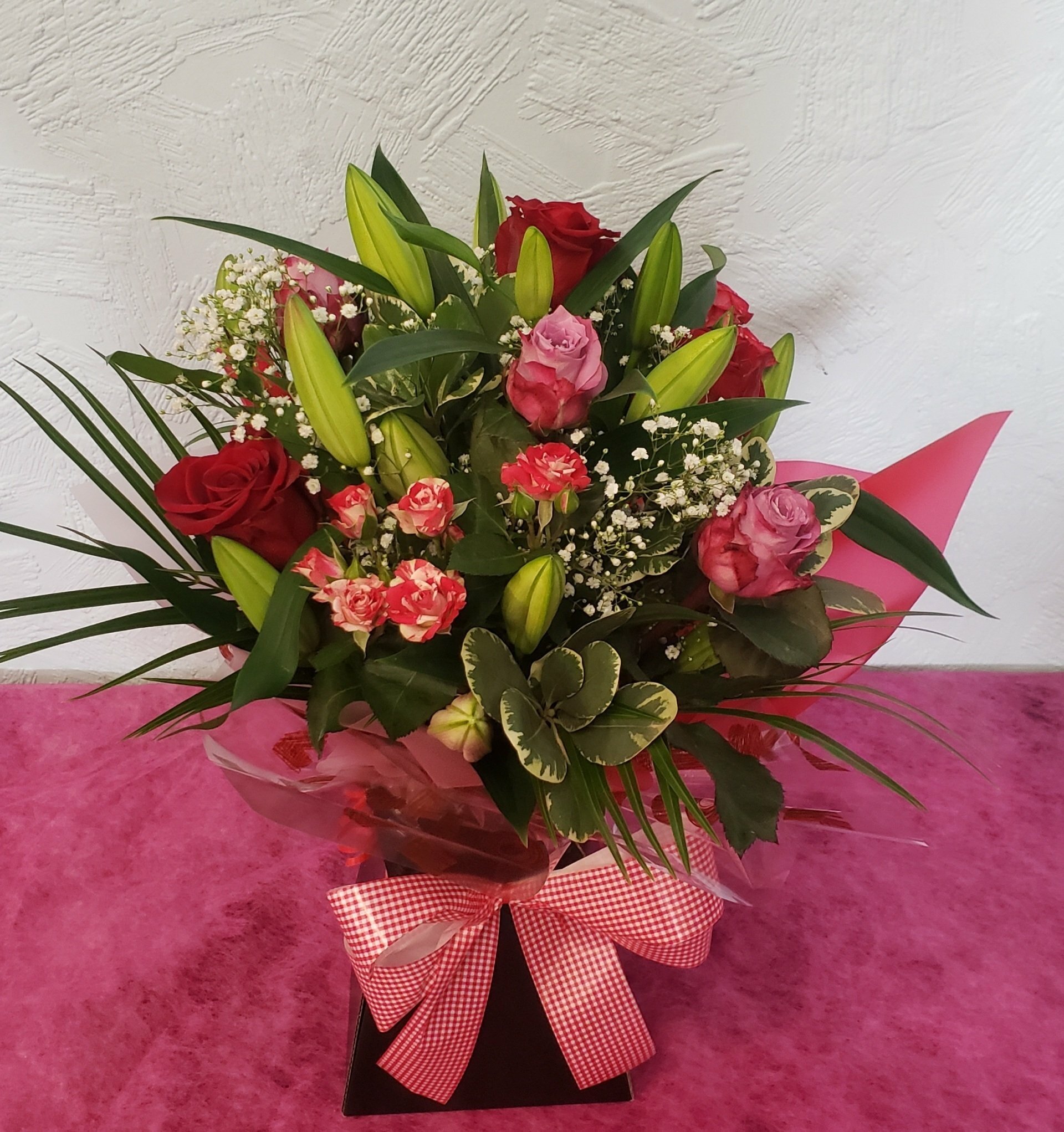 Christmas Aqua packed Lily and rose Bouquet with seasonal foliage for Local delivery starting from £60.00