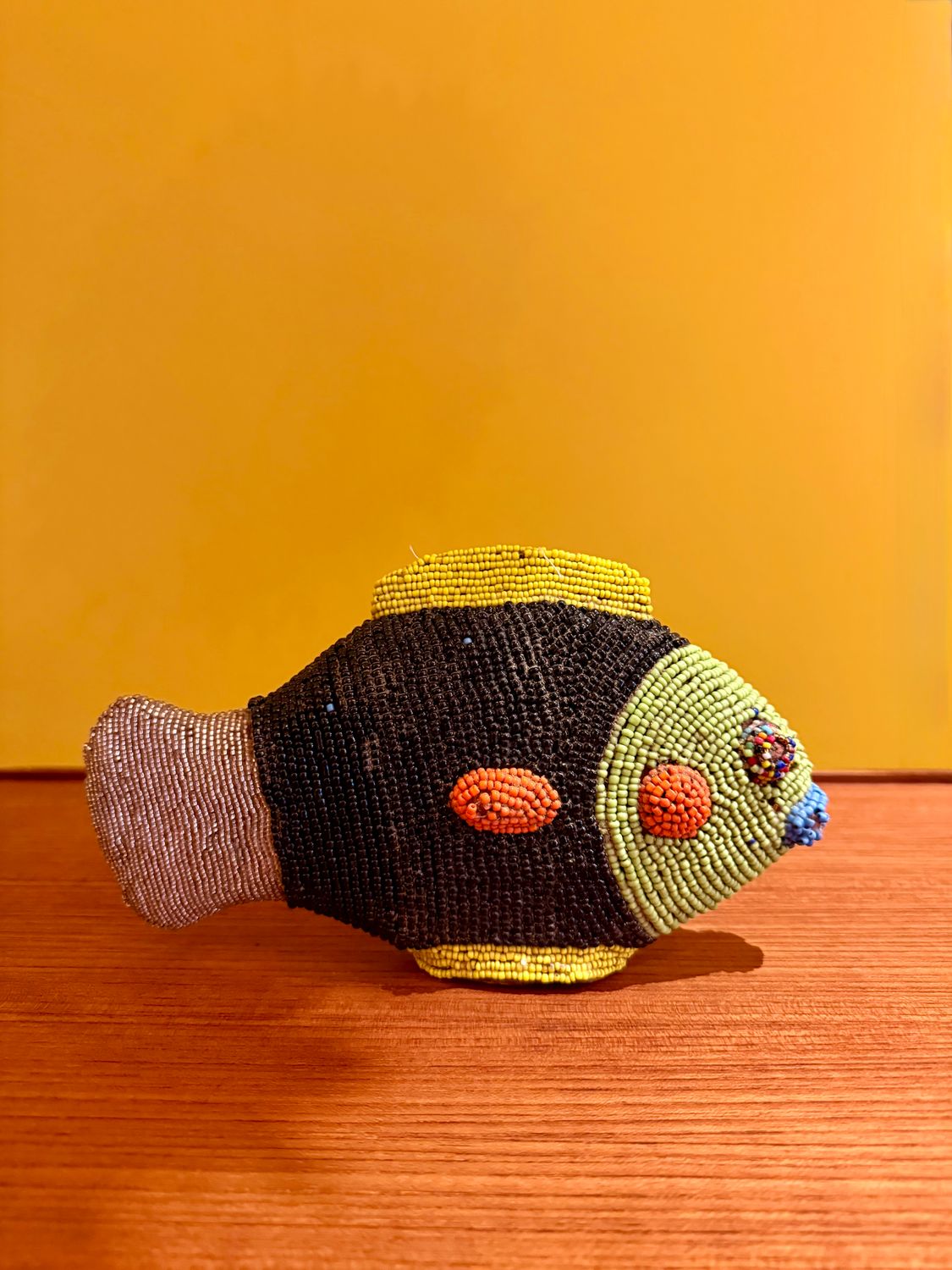 Handgemaakte decoratieve vis volledig bedekt met kleurrijke glaskraaltjes