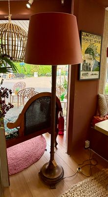Klassieke vloerlamp met rijkversierde houten zuilvoet en rode kap