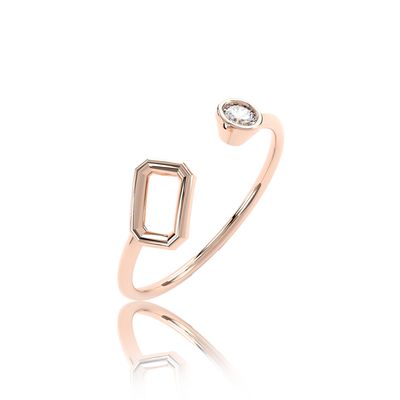 Bague ouverte de couleur or rose avec une monture rectangulaire vide et une pierre ronde, sur un fond uni gris clair.