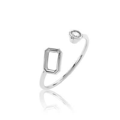 Bague ouverte de couleur argent avec une monture rectangulaire vide et une pierre ronde, sur un fond uni gris clair.