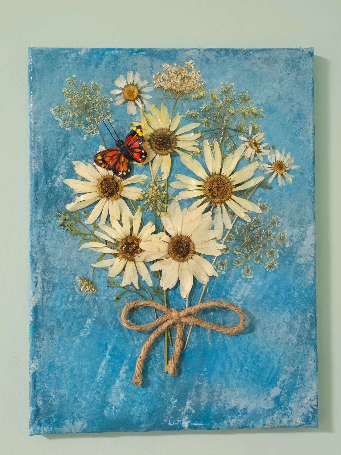  . dried daisy wall art

 . 9x12 floral canvas decor

 . real flower art on canvas

 . acrylic and resin wall art

 . handmade daisy flower painting

 . resin coated flower art

 . botanical canvas art

 . cottagecore daisy decor

 . pressed flower art on blue background

 . nature-inspired wall decor