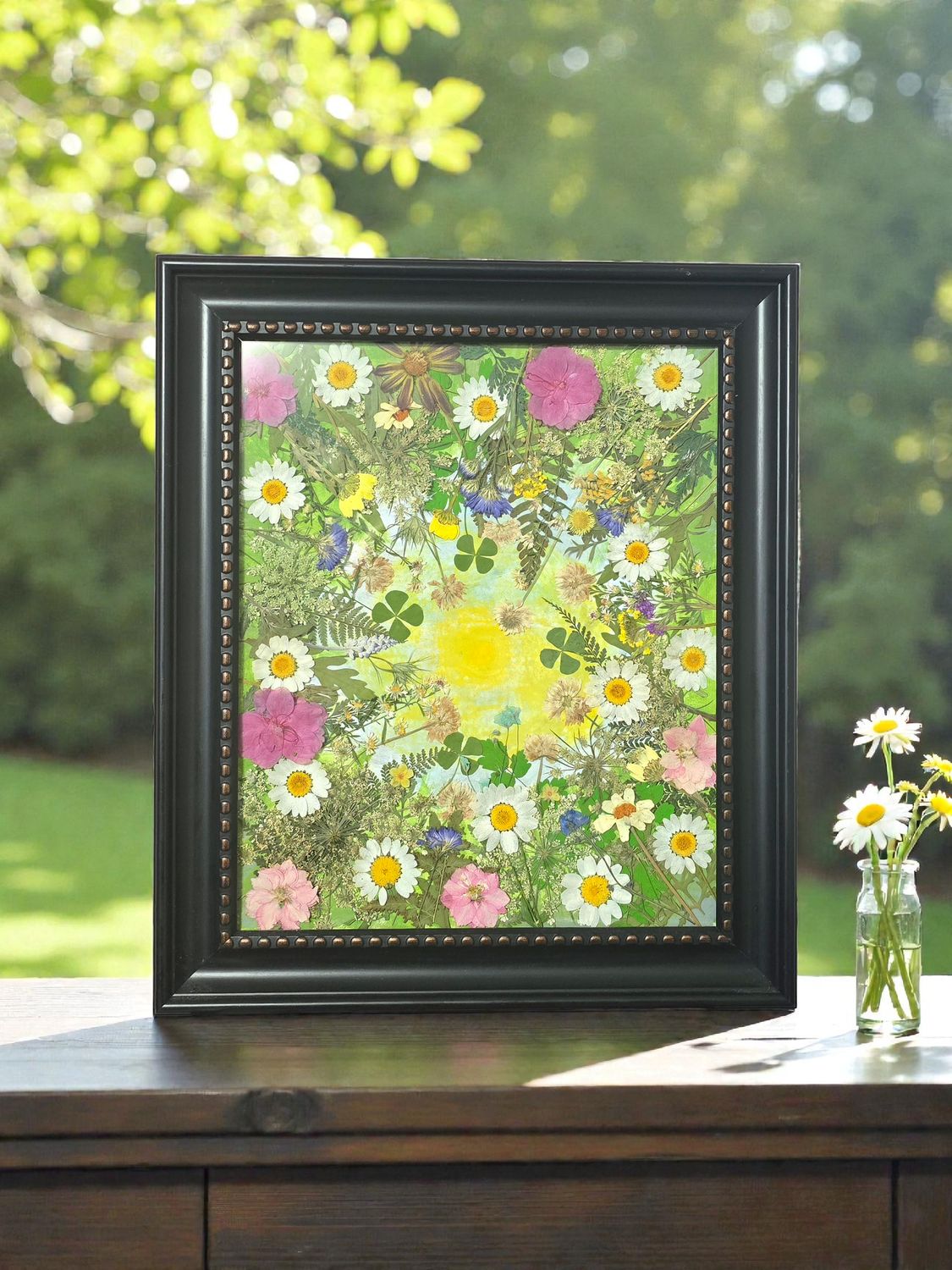 Framed pressed flower art with colorful real dried flowers and painted yellow sun in the center