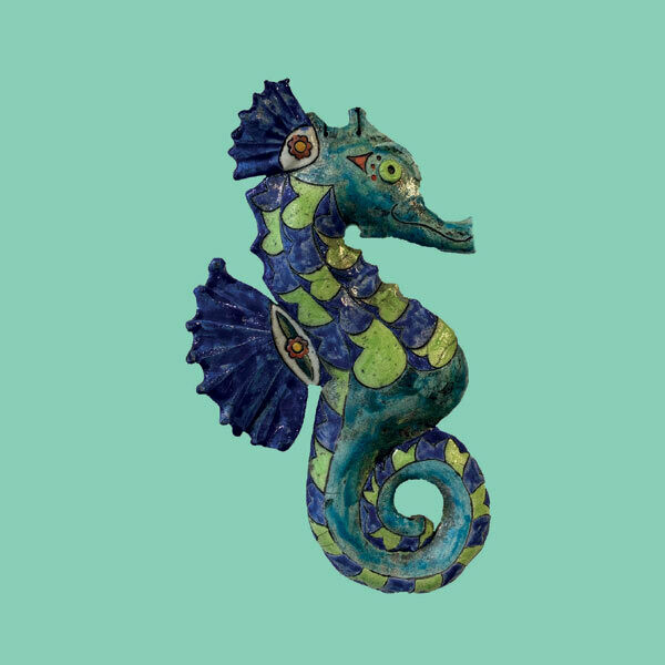 Raku seahorse on a green card by Annabel Langrish