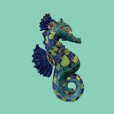 Raku seahorse on a green card by Annabel Langrish
