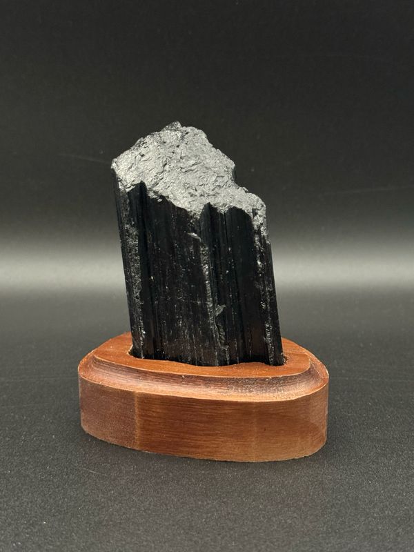 ​Schwarzer Turmalin Rohstein auf Holzsockel