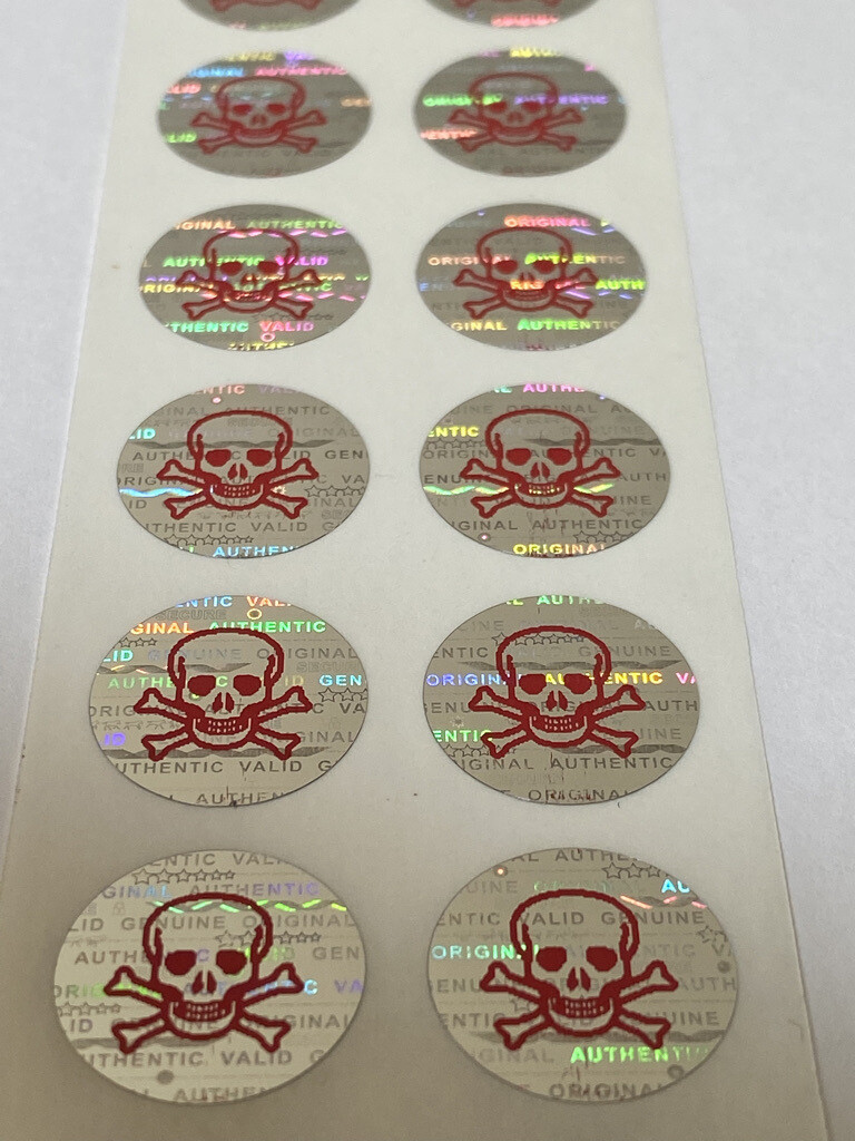 .625 inch round tamper evident hologram label w/ skull and crossbones