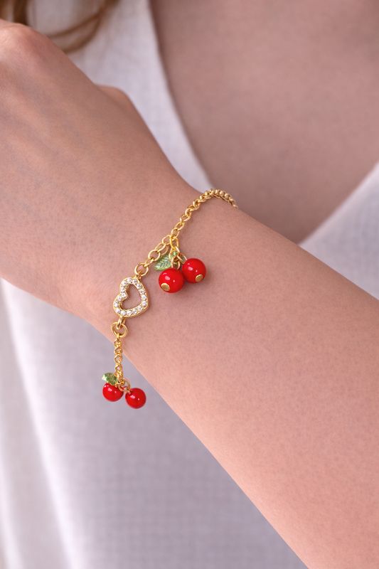 Goudkleurige armband met kersjes.