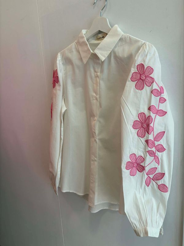 Witte blouse met roze geborduurde hartjes.