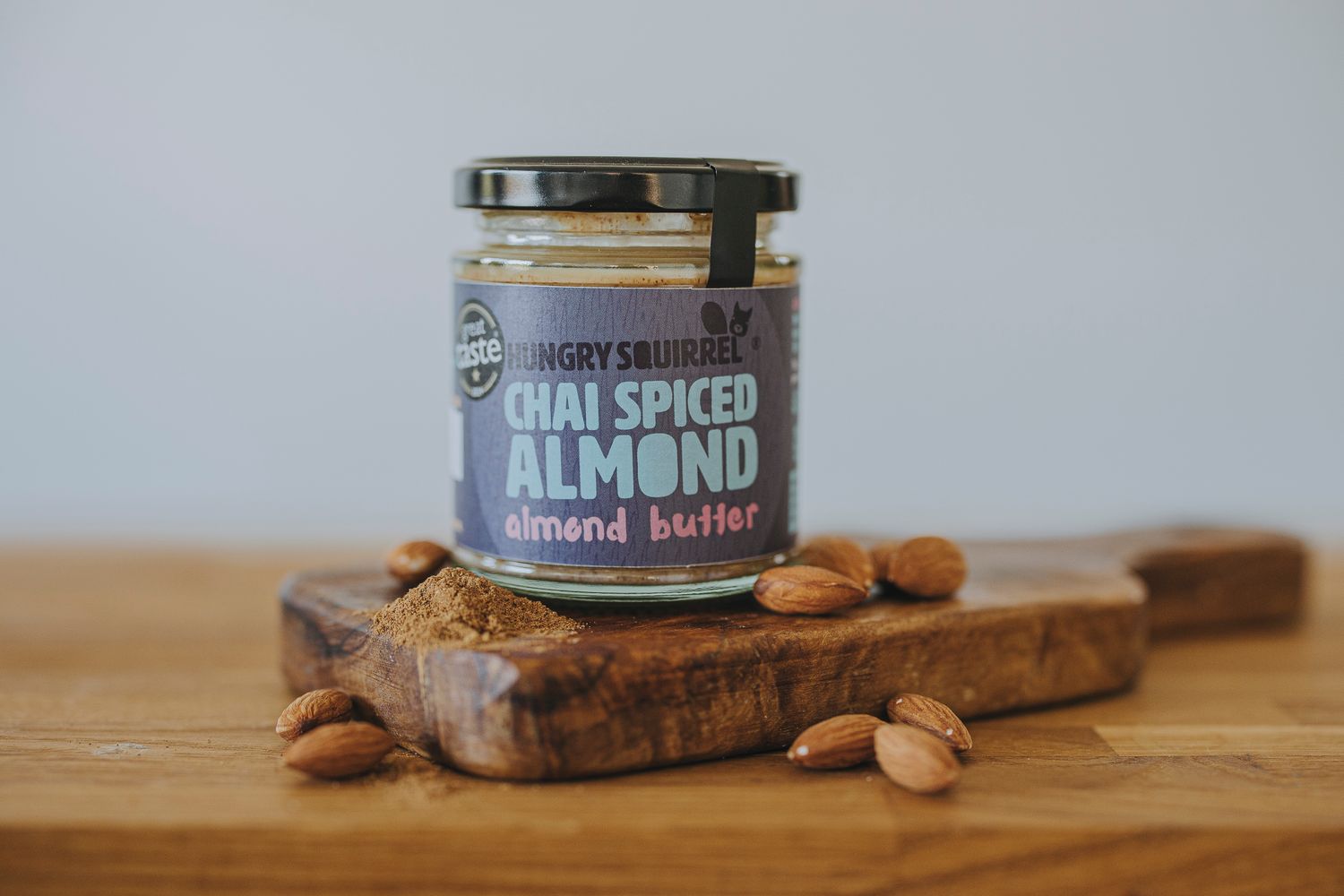 jar of Chai Spiced Almond Butter on a wooden board with whole spices beside it.