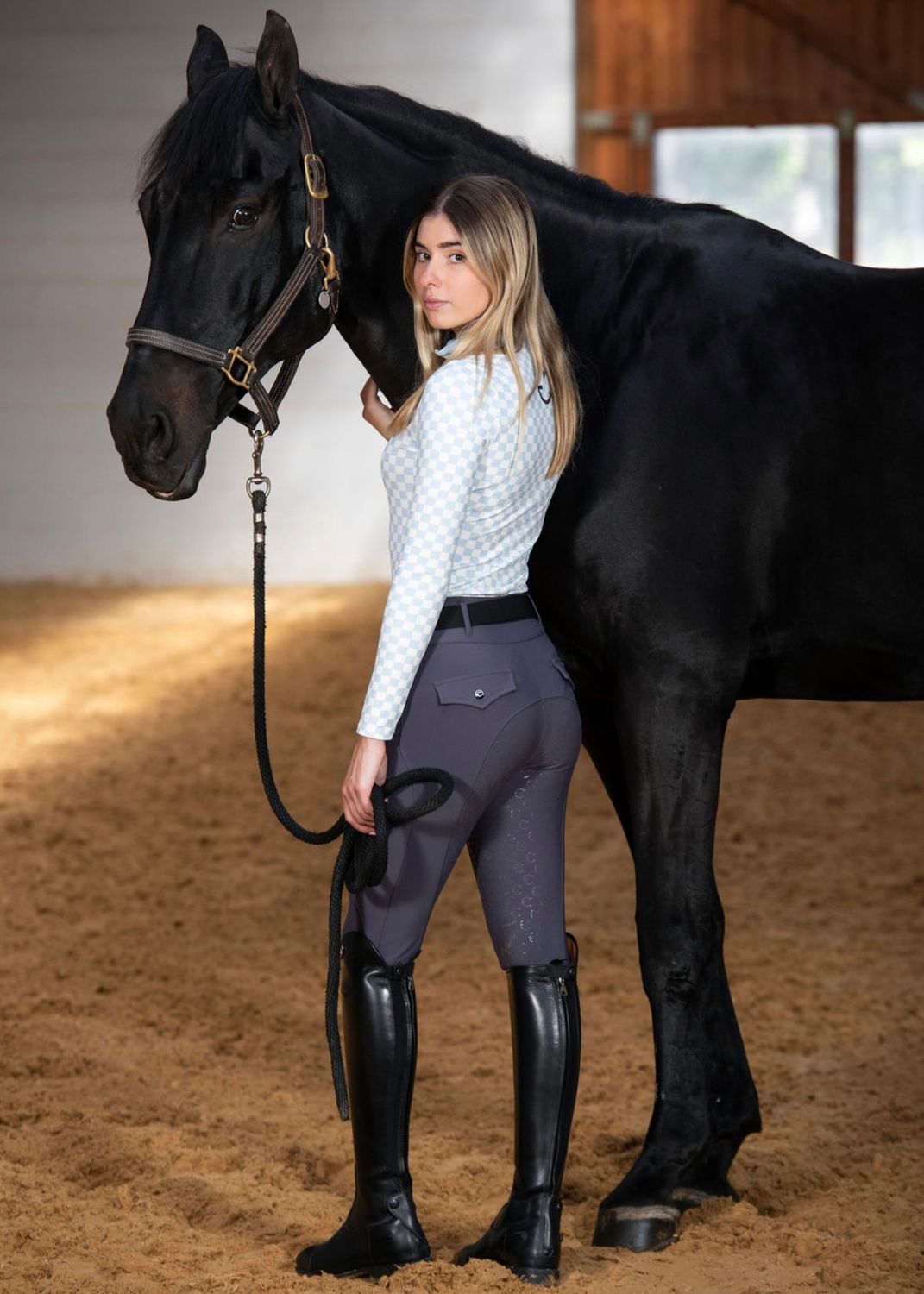 Model and her horse wearing the Mia long-sleeved plaid sweater in pastel blue and white