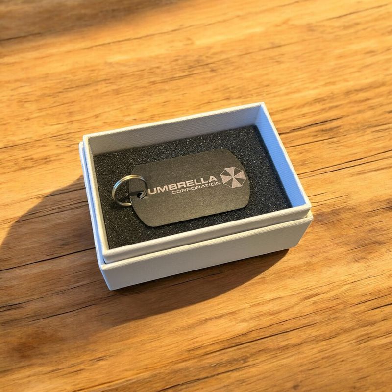 Schlüsselanhänger Umbrella Corp. mit Kennzeichen u. Name