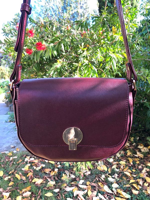 Val sac cuir de couleur bordeaux, porté bandoulière ou épaule anse réglable. Forme vintage. Conçu et fabriqué à Toulouse