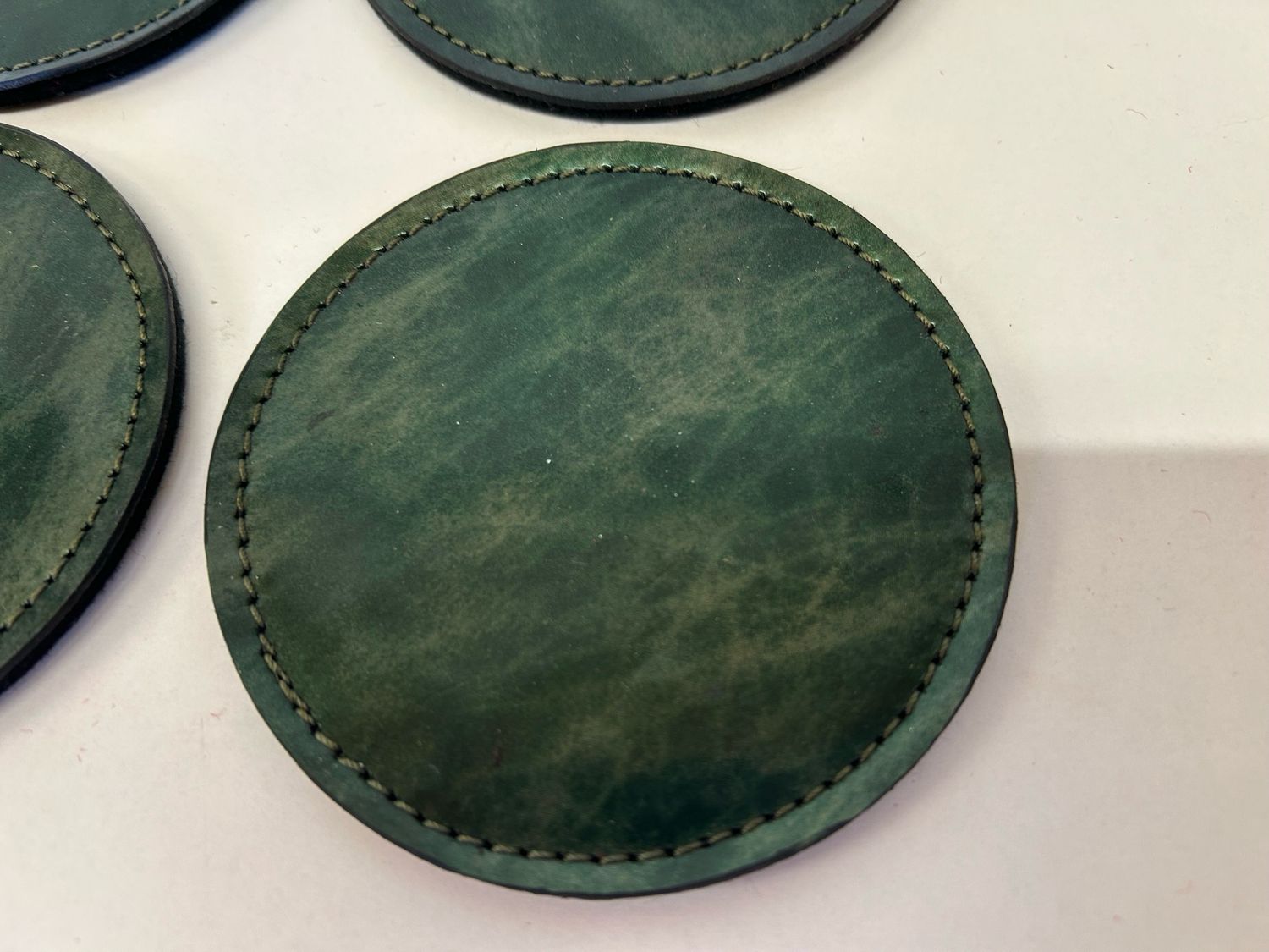 Sous verre en cuir pleine fleur de vachette vernis de couleur marbré vert, vendu par 6, avec support fabriqué à Toulouse , pièce unique .