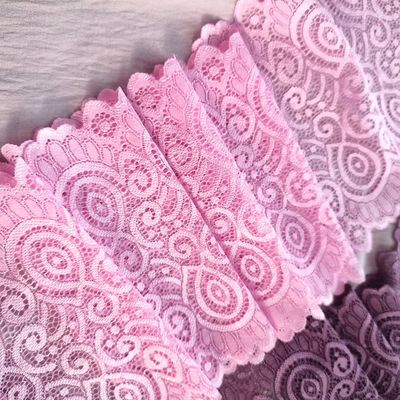 Bright pink stretch lace with paisley design and scalloped edges laid