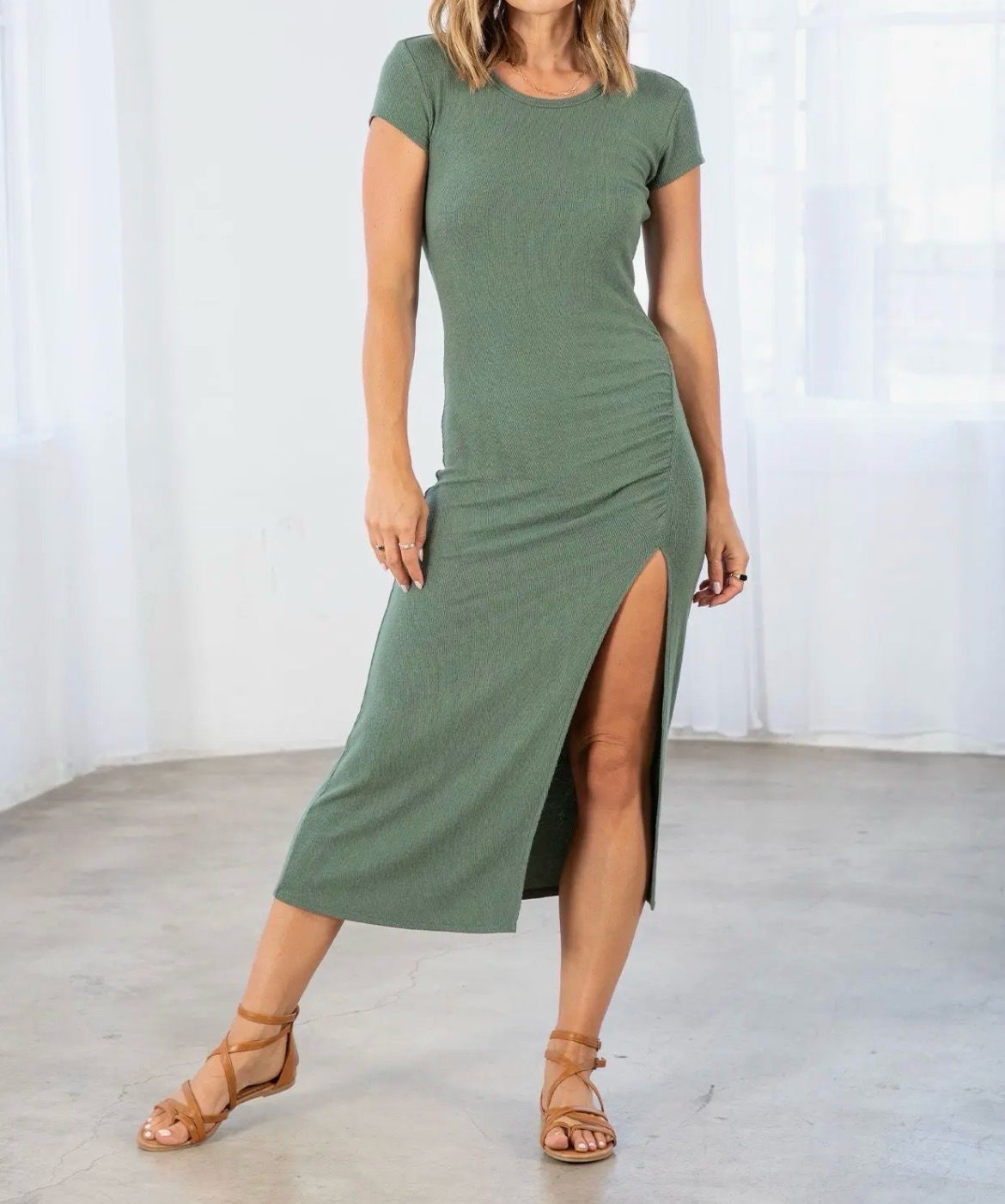 Woman wearing Lovestitch army green bamboo micro-rib midi dress with ruched side slit.