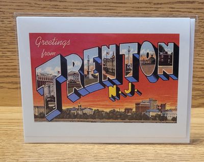 A greeting card that says 'Greetings from Trenton' in a vintage font, featuring a red sunset with the Trenton skyline.