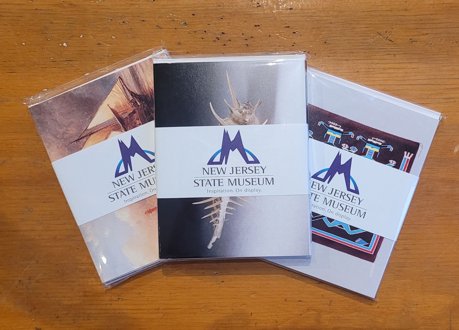 Three packs of notecards from the New Jersey State Museum collection on a wood-toned background.