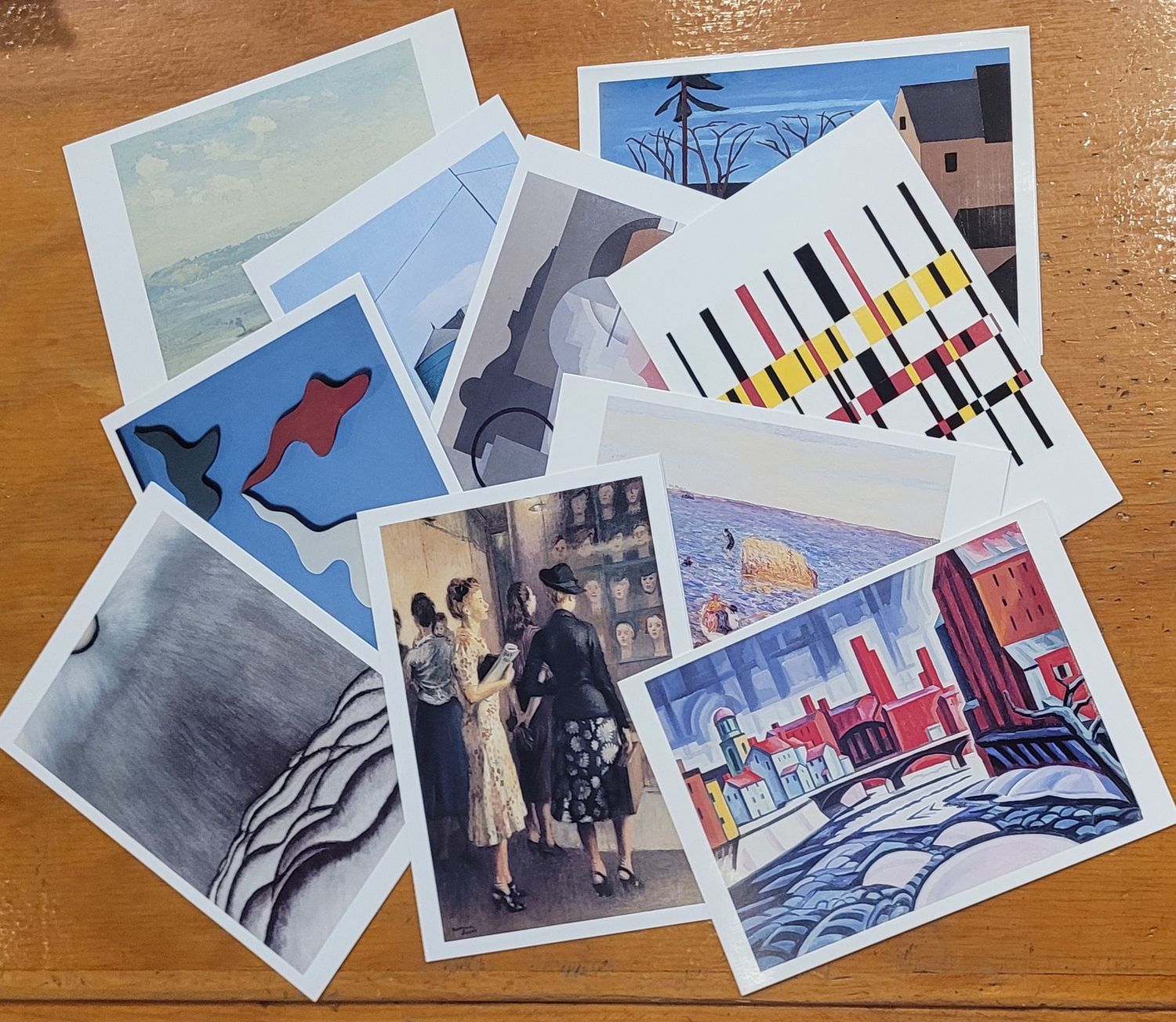 A collection of notecards featuring art from the New Jersey State Museum collection scattered across a desk.