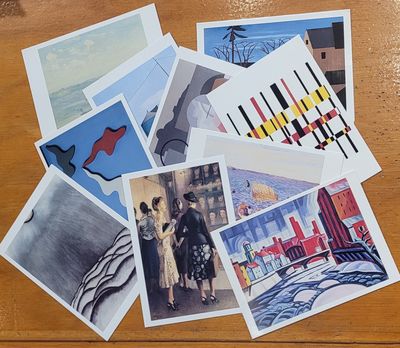 A collection of notecards featuring art from the New Jersey State Museum collection scattered across a desk.
