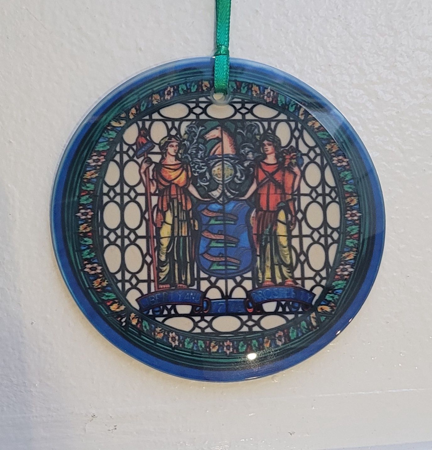 A stained glass ornament featuring the Great Seal of New Jersey from the New Jersey State House