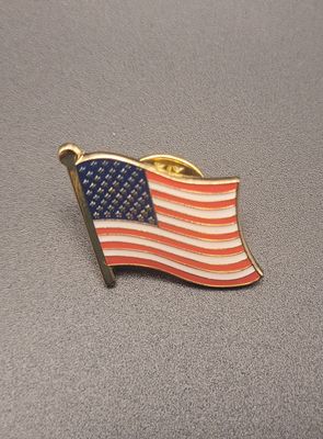 A lapel pin featuring the American flag on a black background.