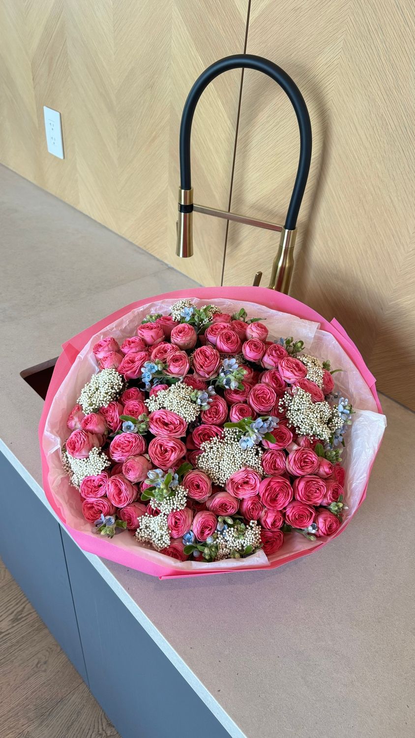Top view of luxury bouquet with raspberry garden spray roses, white rice flowers and blue oxyopetalum – Miami flower delivery