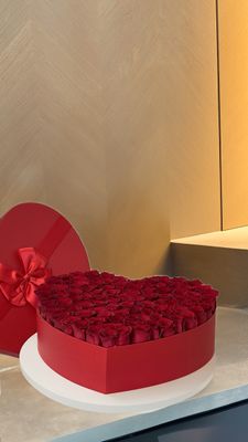 Heart-shaped red box filled with red roses and ribbon-tied lid – luxury flower delivery Miami &amp; Naples