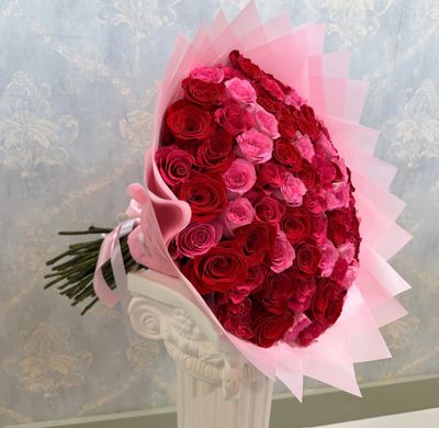 Bouquet of 100 long-stem pink and red roses wrapped in elegant soft pink paper
