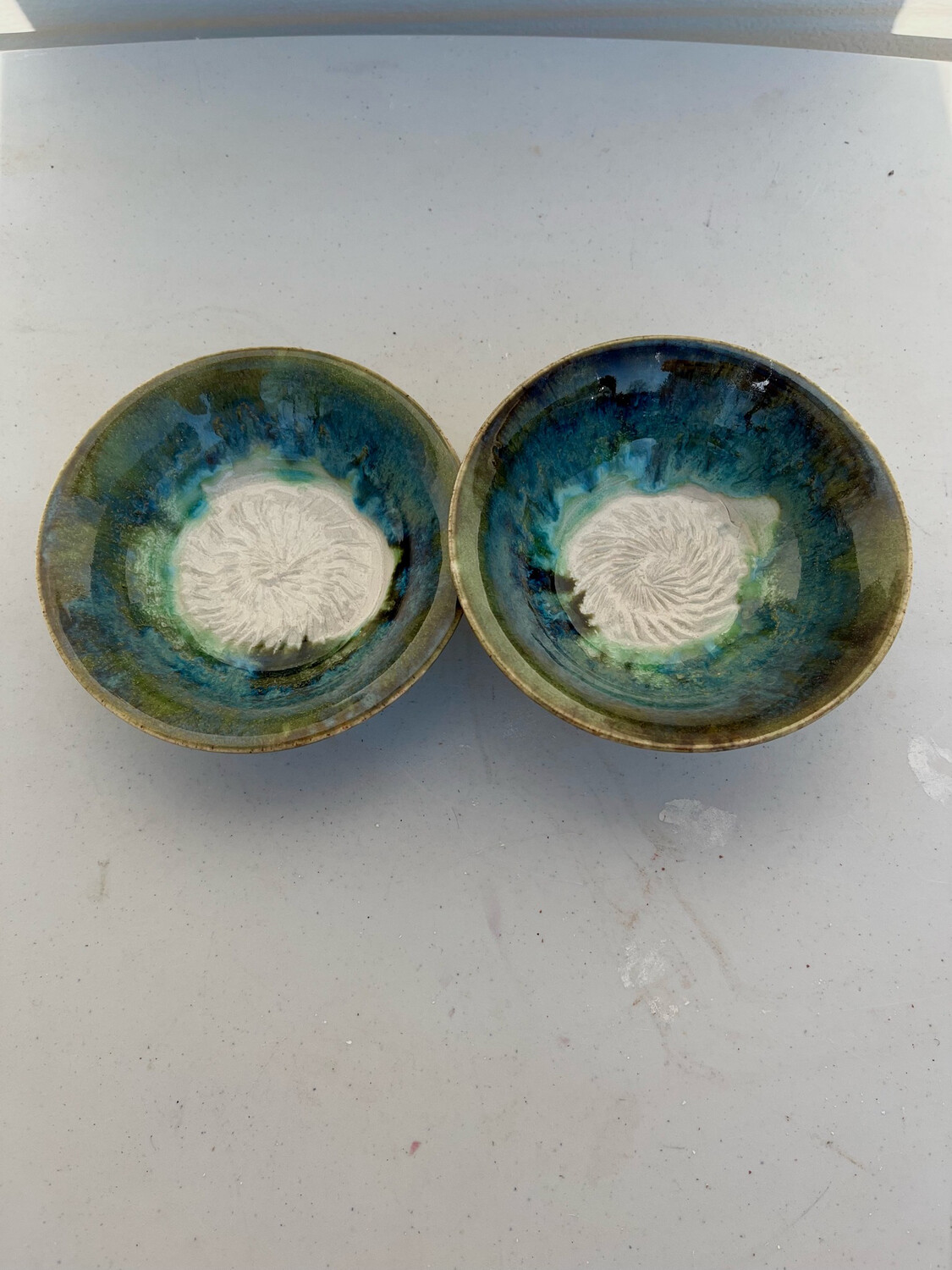 two small snack bowls with swirl pattern In the center