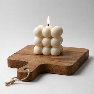 Kreemikas sojavahast bubble-küünal valgel taustal – minimalistlik käsitööküünal