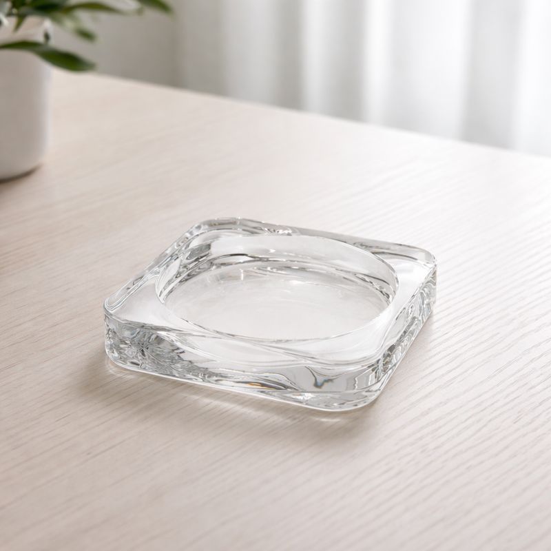 Läbipaistev klaasist küünlaalus skandinaavia stiilis heledal puidust laual