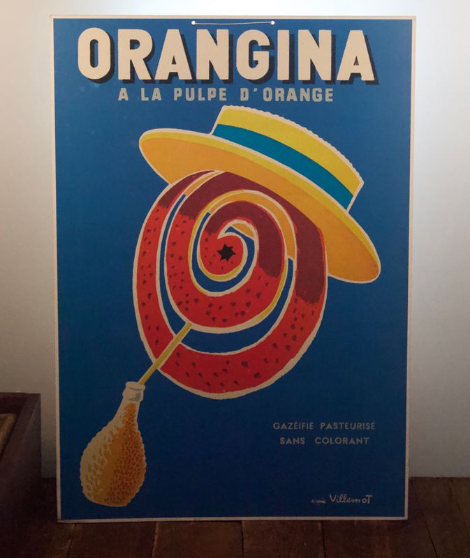 Vintage Orangina reclameposter met blauwe achtergrond, gele hoed en spiraalvormige sinaasappelillustratie.