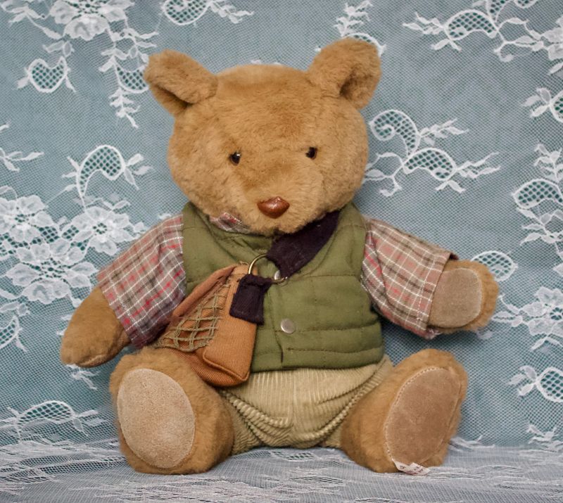 Voorkant Bo‑Bear Designs teddybeer met groene bodywarmer, geruite blouse en licht verkleurde corduroy broek