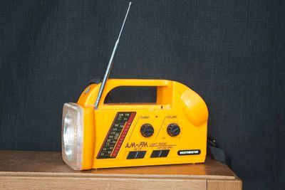 Vintage oranje Westminster noodradio met lamp, draagriem en antenne