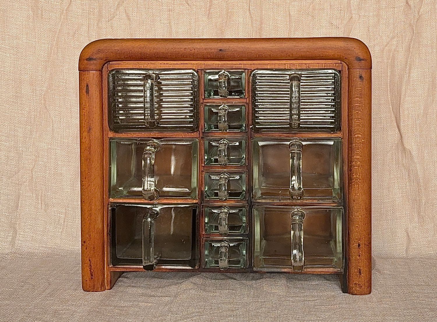 Compleet art deco kruidenrek met 12 originele glazen bakken, waaronder Cubex en Poncet. Massief houten kastje, jaren 30.