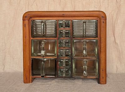 Compleet art deco kruidenrek met 12 originele glazen bakken, waaronder Cubex en Poncet. Massief houten kastje, jaren 30.