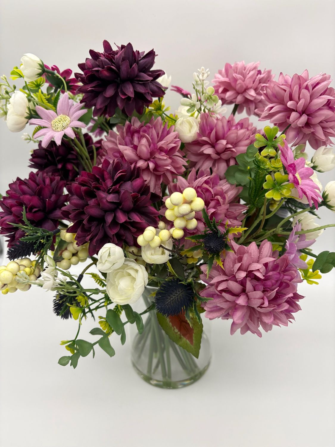 Floral arrangement in pink, plum &amp; cream in glass vase