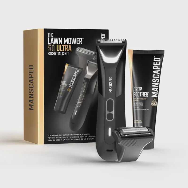Manscaped Lawn Mower 5.0 electric trimmer displayed with all attachments and accessories next to its packaging box.