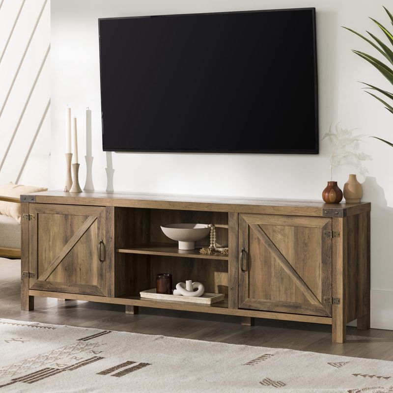 Walker Edison Rustic Barndoor TV Cabinet in rustic oak finish with a flat-panel TV on top.